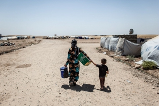  Une réfugiée et son enfant se dirigent vers leur tente. Dans le camp de Domiz, près de 50.000 réfugiés vivent dans des conditions sanitaires inquiétantes.