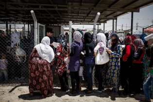  Refugees queueing up at the World Food Program food ticket distribution office. Monthly the World Food Program allows 31 USD for each member of a family.