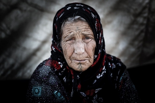  Portrait of an old woman before his tent. Refugees go out of  their tent at the end of the aftrnoon when temperatures go down.