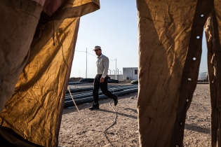  A refugee walks by a storage tent.